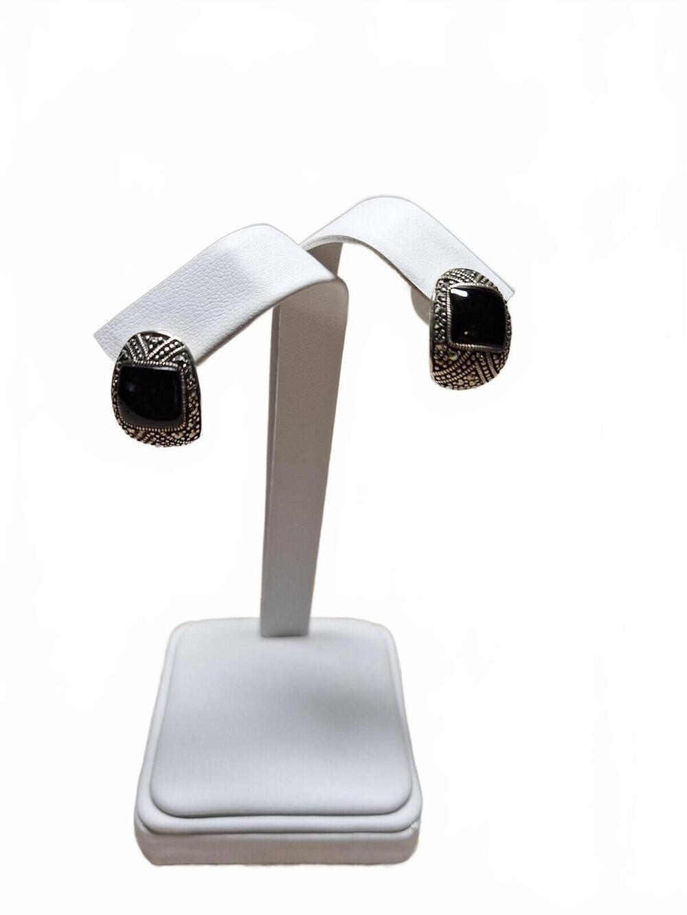 Black onyx and marcasite earrings sits on ear in sterling silver